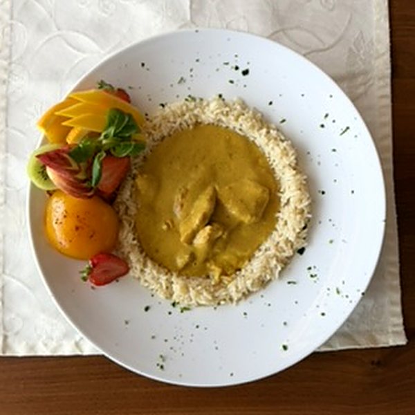 Currygeschnetzeltes vom Hühnerfilet im Reisring, garniert mit Früchten – von oben