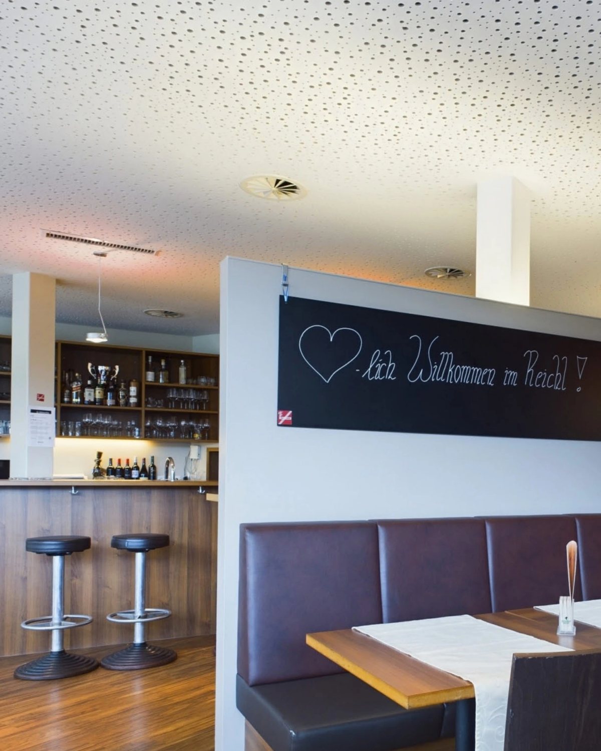 Gemütlicher Gastraum im Cafe Reichl mit „Willkommen“-Tafel